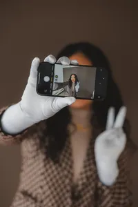 A woman takes a selfie with the phone pointed towards the viewer