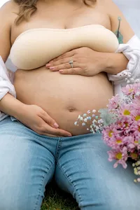 Close up of flowers near a pregnant belly