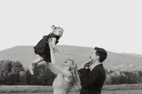Jess and Corey Combs looking up at their daughter smiling in Manchester, Vermont