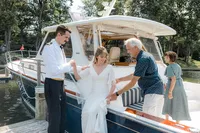 Man helping bride onto boat