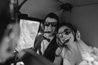 Black-and-white photo of the newlyweds smiling together in sunglasses and headsets during their helicopter flight over Alaska.