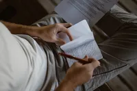 Close-up of the groom writing his private vows by hand in a small notebook before the Alaska elopement.