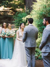 bride smiling at groom during their woodsy wedding ceremony