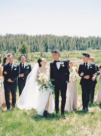 Tannenbaum wedding party laughing and walking in the meadow