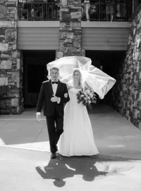 brides veil in the air during her ceremony walk with her father at the chateau at incline village