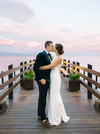 bride and groom kissing on the pier