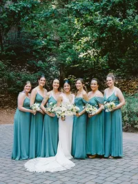 bridesmaids in turquoise dresses posing with bride