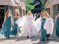 bride is walking to First Look covering herself with white sheet so no one sees her dress