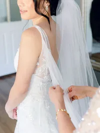 mother of the bride helping bride with veil adjustments