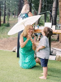 wedding guest with sum umbrella showing it to the boy