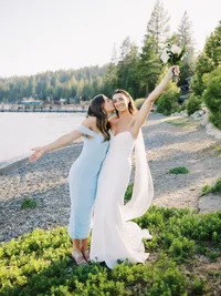 bride and her bridesmaid celebrating at the wedding reception on the beach