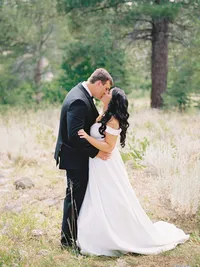 bride and groom kissing in the meadow