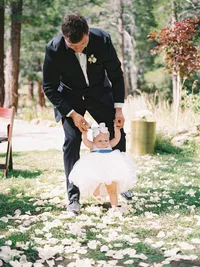 groom is walking down the isle with his baby daughter
