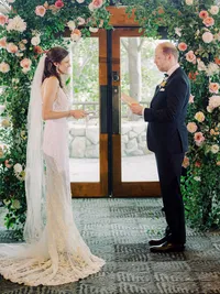 Indoors wedding ceremony at Edgewood with bride and groom reading vows
