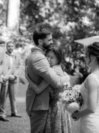 groom embraces brides mom during wedding ceremony