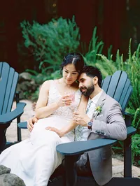 bride sitting on grooms lap drinking cocktails