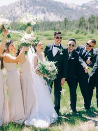 bride with groom and wedding party laughing and cheering