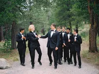 groom and groomsmen cheering and walking to the wedding ceremony at The Dancing Pines