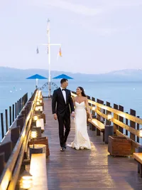 bride and groom walking down the dock at Gar Woods Tahoe during alpine glow