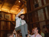 groom is picked up in the chair at his wedding reception
