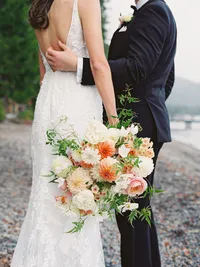 bride and groom holding huge flower bouquet
