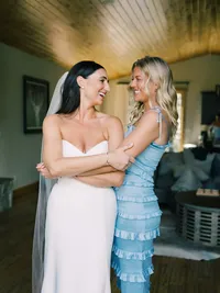 bride and her maid of honor hugging and laughing