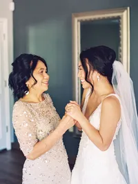 bride and her mother holding hands during getting ready