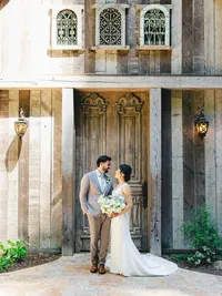 Bride and groom looking at each other by the barn door at waterfall lodge
