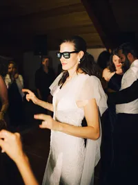 bride ricking wedding sunglasses at her reception