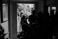 documentary creative portrait of bride and groom sneaking a kiss before their home wedding ceremony
