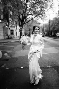candid nostalgic portrait of bride walking and holding long dress