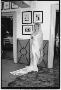 Editorial wedding photo of bride leaning against picture wall of Brunswick house captured on 35mm film