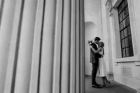 creative wedding photo of a wedding couple kissing at colonnade of old marylebone town hall