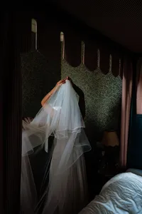 Bride putting a long veil on at london hotel wedding