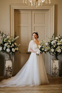 Romantic wedding photography of bride standing between flowers in natural light of admiral house in Greenwich