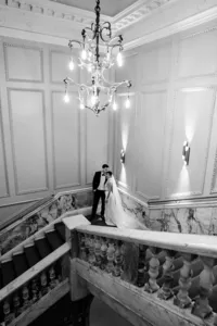 modern wedding portrait with bride and groom posing at marble staircase of andaz hotel in london