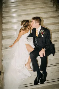 editorial direct flash photo of bride and groom sitting on stairs and sharing a kiss on film