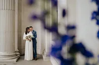 modern london wedding couple with bridal suit hugging at old marylebone town hall colonnade