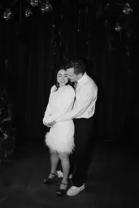 Nighttime portrait of groom hugging bride at hackney wedding
