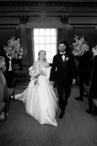 cinematic wedding photo of smiling bride and groom leaving westminster room of marylebone town hall