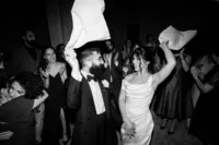 bride, groom and guests dancing with napkins in the air at andaz hotel wedding party