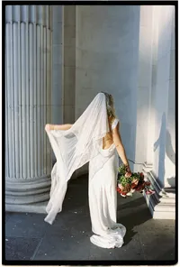 film wedding photograph of bride in winter light playing with veil at iconi marylebone town hall stairs