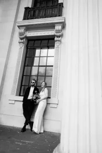 nostalgic creative wedding portrait of bride and groom leaning on marylebone town hall window