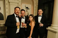 black tie wedding guests posing with drinks at andaz bar