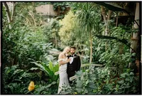 romantic wedding portrait of bride and groom among foliage of barbican conservatory, analogue wedding photography