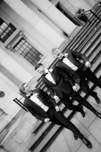 editorial photo of groom and groomsmen in black tie walking and laughing at marylebone steps