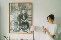 documentary artistic wedding photo of bride putting jewellery on near a big painting taken by film wedding photographer