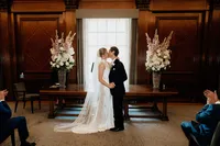 bride and groom sharing first kiss at westminster ceremony room of marylebone town hall in london