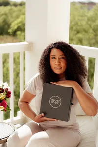 woman peacefully smiling holding her journal