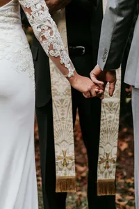 Close-up of bride and groom's hands together showing their wedding rings